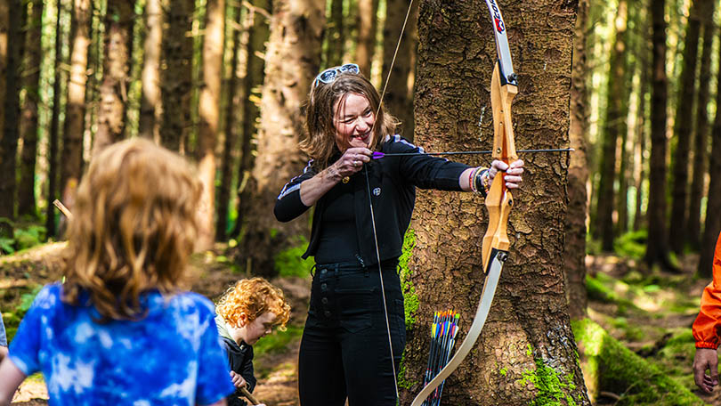 Family enjoying archery activity in a forest in County Limerick