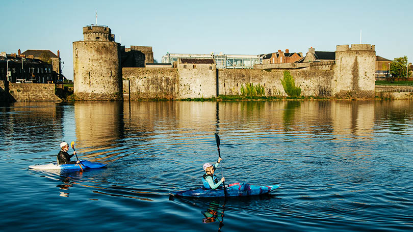Two woman kayaking on the River Shannon in front of King John's Castle. Photo: Sean Curtin