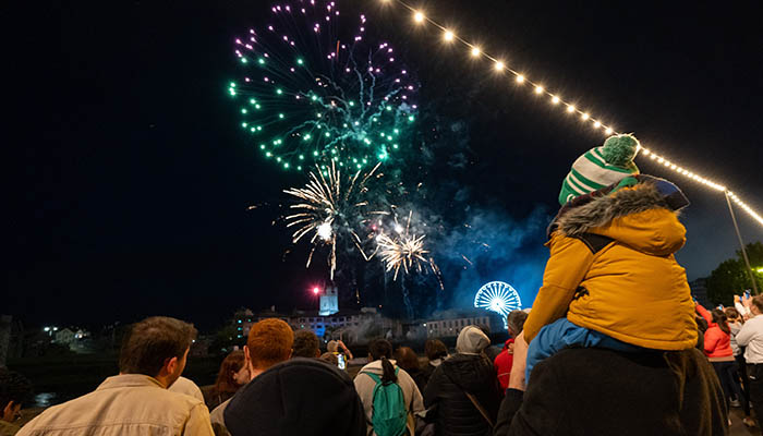 Crowd of people watching fireworks over the River Shannon in Limerick